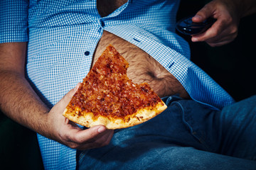 man with a beer belly eating pizza