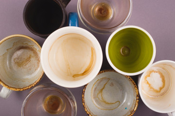 Several empty cups of coffee viewed from above on gray table. Top view layout.