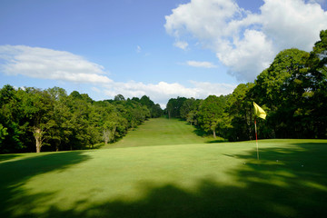 The evening golf course has sunlight shining down at golf course in Thailand