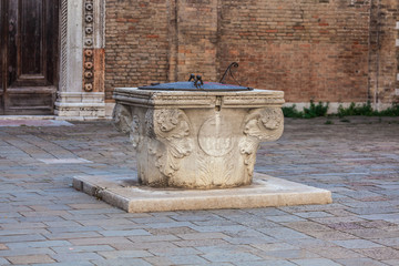 Ancient stone well for rain water in a square in Venice