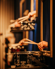 The drummer plays the drums. Beautiful blue  background, with rays of light. Beautiful  lighting. The process of playing a musical instrument. Close-up photo.