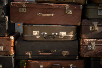Stack of aged suitcases stacked in a heap. Traveling concept. Background