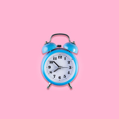 Blue vintage alarm clock on light pink color background. Alarm clock with place for text. Time management concept, business planning. Top view. Square image.