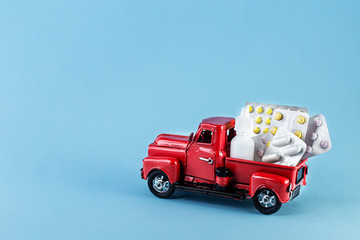 Toy car truck with pills on a blue background. Copy space for your design.