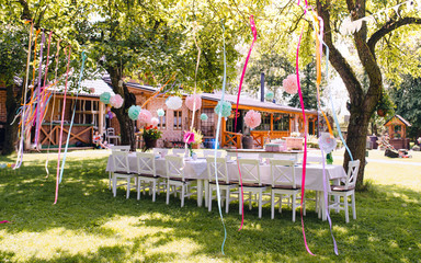 A table set for kids birthday party outdoors in garden in summer.