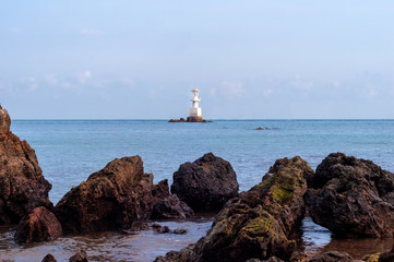 White Lighthouse Standing on The Rocks