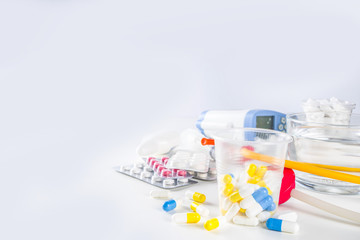 Pharmaceutical medicine pills concept, Assorted various pills, tablets and capsules with medical syringes, thermometer and water glass, copy space mockup, flatlay