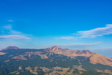 Fototapeta na wymiar 晴天の青空を背景に 美しい景色　阿蘇山の噴火　クローズアップ 　南阿蘇方面から阿蘇五岳を撮影 　日本　Against the clear blue sky Beautiful scenery-Mt. Aso eruption-Close-up Take a picture of Aso Godake from the southern Aso area　 Japan