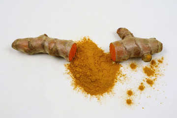 Fresh turmeric and turmeric powder, isolated on a white background, are ingredients in the diet....