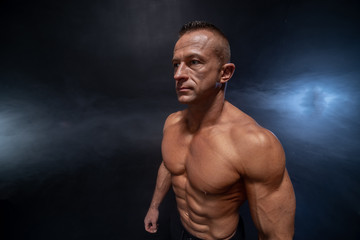 Fototapeta na wymiar Muscular man isolated on the black background. Strong male naked torso abs