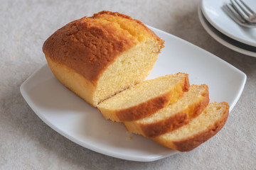Butter cake loaf or pound cake sliced on plate.