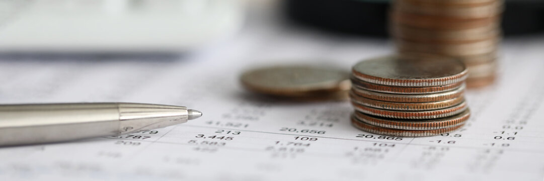 Silver Pen Lying Over Financial Statistics Paper With Set Of Numbers