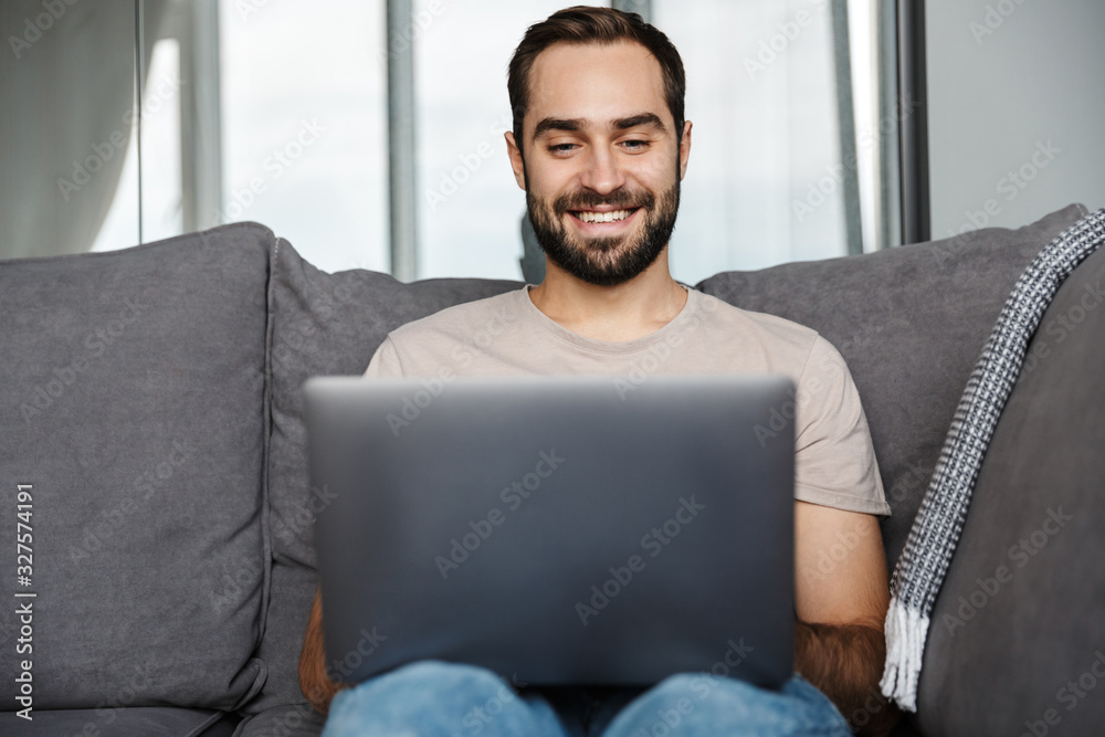 Wall mural Happy positive young man indoors at home