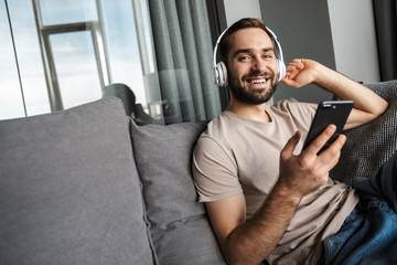 Positive man listening music with headphones