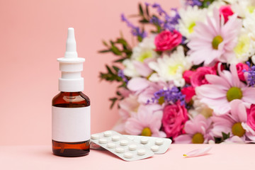 Fototapeta na wymiar Allergy to flowers. Allergy spray medicine and pills against the background of flowers and pink background