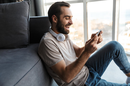 Optimistic Young Man Play Games By Mobile Phone