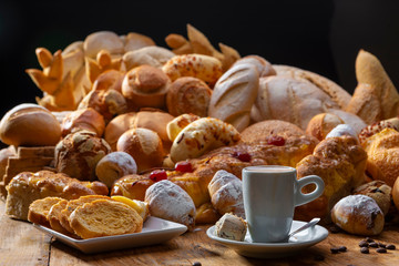 mesa de café da manhã com pães, doces e confeitos
