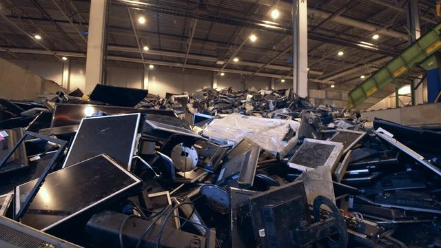 Many monitors in a pile in a recycling center.
