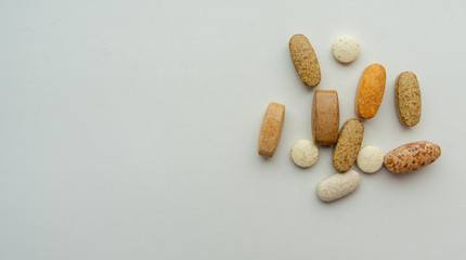 A variety of pills on a plain background.
