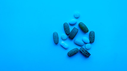 Different pills on color background.