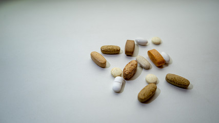 A variety of pills on a plain background.