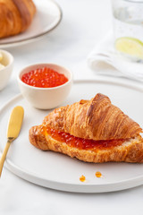 Red caviar and croissant for breakfast, selective focus. Luxury breakfast.