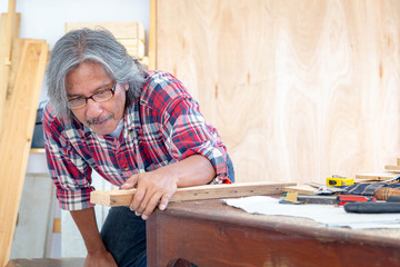 Carpenter man working in woodwork workshop. The wooden industry. Invention and crafts concept.