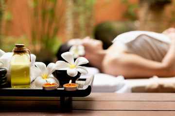 Obraz na płótnie Canvas Close up Spa items. Background asian woman lying down on massage bed with scrub sugar and salt aroma at outdoor natural. wellness center, so relax and lifestyle. Thai Day Spa. Healthy Concept
