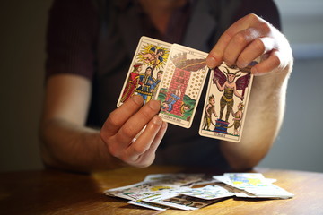 Men's hands hold tarot cards