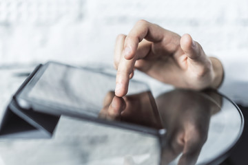 Male hand working with digital tablet in sunny office, business and technology concept. Close up