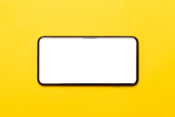 Black smartphone with blank screen mockup isolated on yellow background. Clipping path.