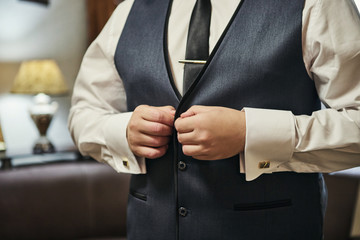 Businessman wears a jacket,male hands closeup,groom getting ready in the morning before wedding ceremony