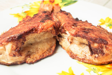 Cooked fried sea bass in plate on kitchen table.