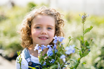 Portrait of small girl standing in the backyard garden.