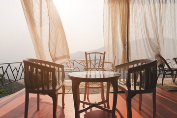 chair on a deck balcony overlooking the mountain at sunset