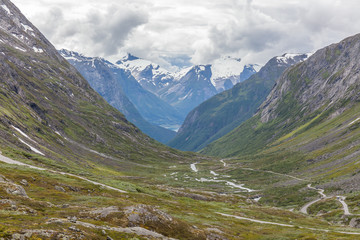 Norway, Beautiful View Of Mountain with cloudy sky and mountain road in green valley, Norway Mountain Landscape selective focus, View from the viewpoint.