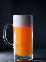Glass mug of wheat craft beer unfiltered on a dark table