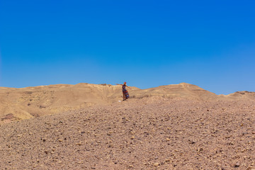 single woman person in fluttering dress freedom concept travel photography in desert dry ground environment outdoor wilderness space without people here horizon background blue sky scenery