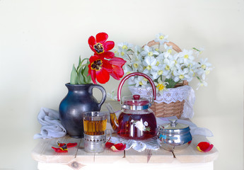 A teapot and a Cup of tea with a bouquet of spring flowers