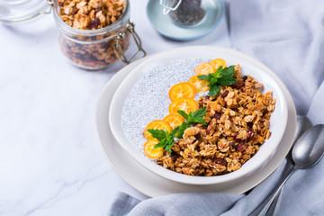 Chia pudding bowl with homemade granola and kumquats for breakfast