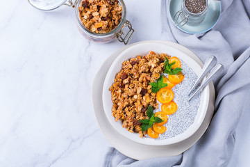 Chia pudding bowl with homemade granola and kumquats for breakfast