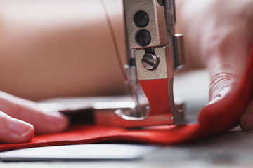 A leather craftsman produces leather goods on a sewing machine in his shop.