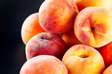 Fototapeta na wymiar Heap of ripe peaches on black background.