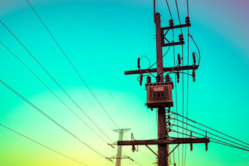 Distribution high voltage transformer for power transmission to industry with sunset sky...