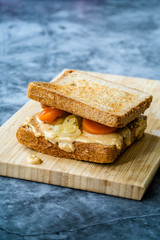 Organic Healthy Homemade Peanut Butter and Pickle Sandwich on Wooden Board.