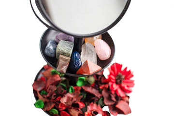 many healing magical stones on a grain support of a mirror close-up.