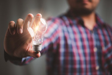 man holding light bulbs, ideas of new ideas with innovative technology and creativity.