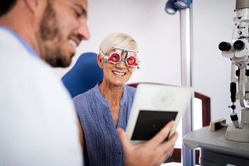 Senior woman taking an eyesight test examination at an optician clinic