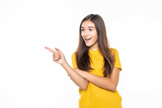 Casual woman pointing to the side and smiling over white background