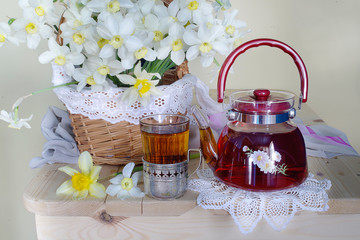 A teapot and a Cup of tea with a bouquet of spring flowers
